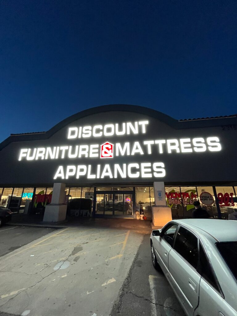 Illuminated channel letter sign on a store at dusk